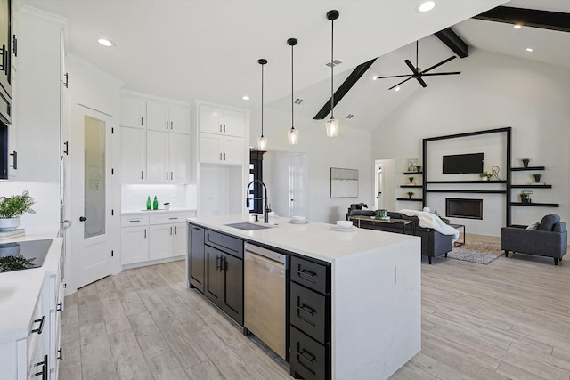 kitchen featuring sink, dishwasher, a kitchen island with sink, white cabinets, and beamed ceiling