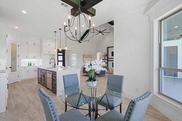 dining room featuring sink, an inviting chandelier, and light hardwood / wood-style floors