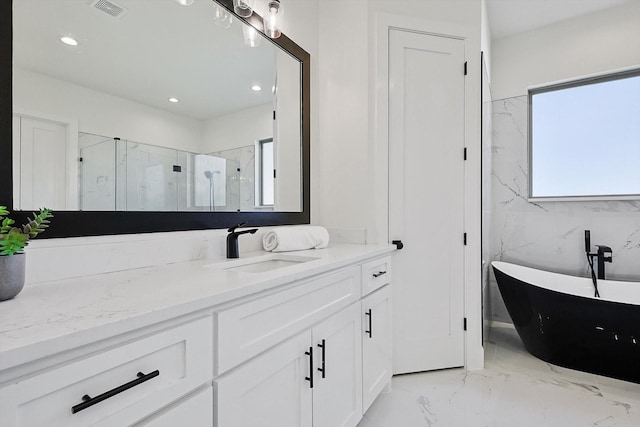 bathroom with vanity and separate shower and tub