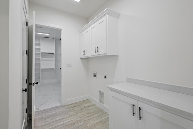 laundry room featuring cabinets, electric dryer hookup, washer hookup, and light hardwood / wood-style floors