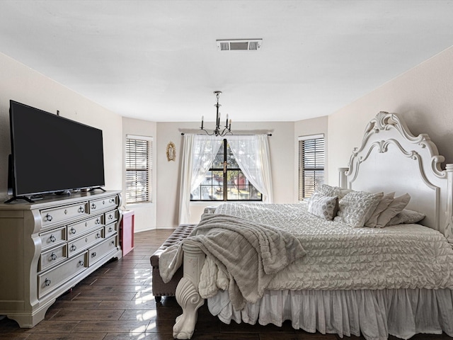 bedroom featuring a chandelier and dark hardwood / wood-style flooring