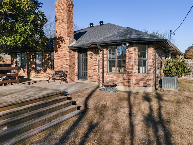 view of front of house featuring cooling unit, a wooden deck, and a patio area