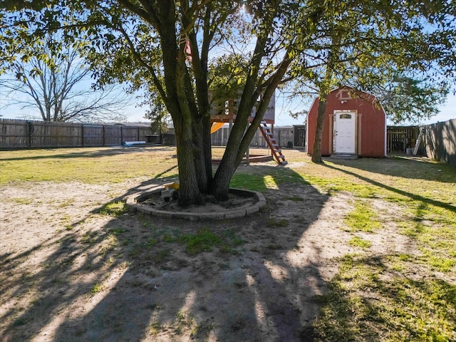 view of yard with a playground and a storage shed