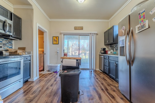 kitchen featuring crown molding, appliances with stainless steel finishes, dark hardwood / wood-style flooring, and decorative backsplash