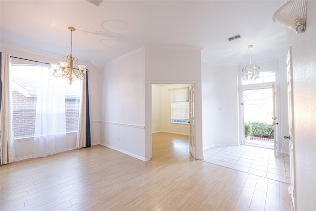 interior space with an inviting chandelier, ornamental molding, and light wood-type flooring