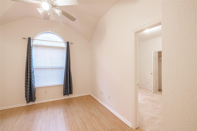 empty room featuring ceiling fan, lofted ceiling, and light wood-type flooring