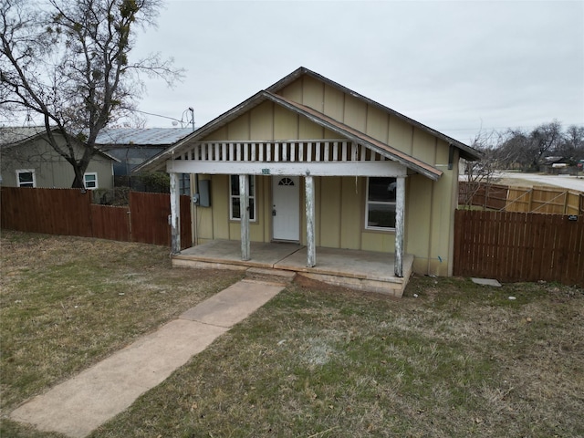 bungalow with a porch and a front lawn