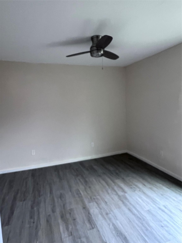 empty room with dark wood-type flooring and ceiling fan