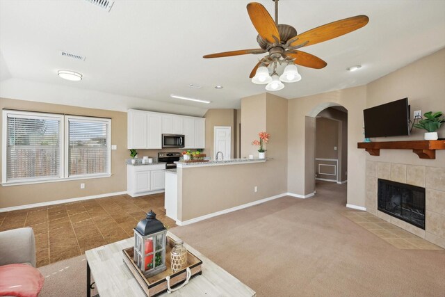 kitchen featuring sink, light stone counters, vaulted ceiling, stainless steel appliances, and white cabinets