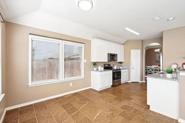 kitchen with visible vents, a sink, white cabinetry, arched walkways, and appliances with stainless steel finishes