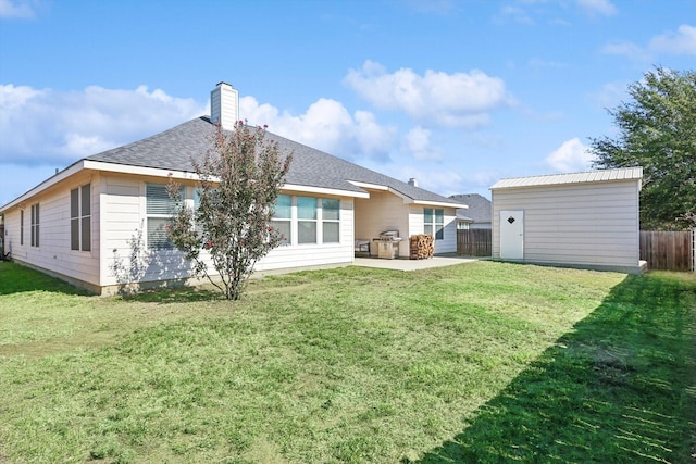 back of house with a patio, an outdoor structure, a yard, and fence