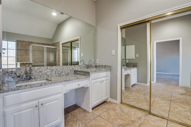 bathroom featuring vanity, tile patterned flooring, vaulted ceiling, and a shower with shower door