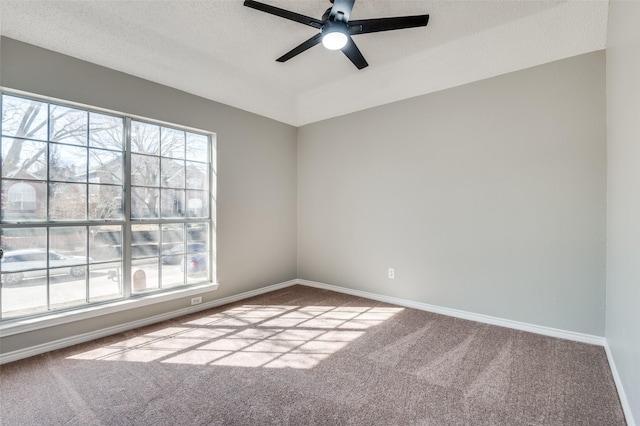 spare room with a healthy amount of sunlight, light carpet, a textured ceiling, and ceiling fan