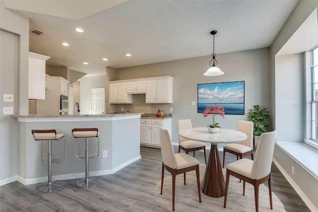 dining area featuring sink and light hardwood / wood-style flooring