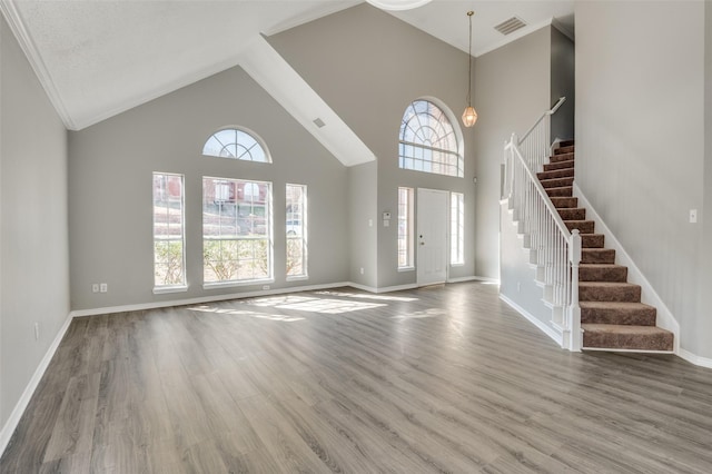 entrance foyer with hardwood / wood-style floors and high vaulted ceiling