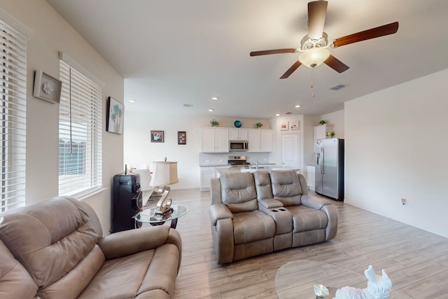 living room featuring ceiling fan and light wood-type flooring