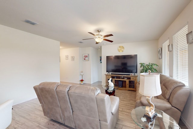 living room featuring ceiling fan and light hardwood / wood-style flooring