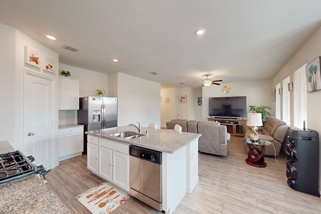 kitchen featuring white cabinetry, stainless steel appliances, a kitchen island with sink, and sink