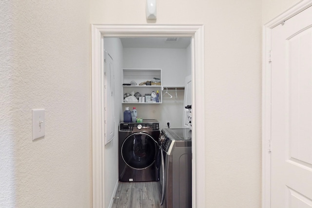 washroom featuring hardwood / wood-style flooring and separate washer and dryer