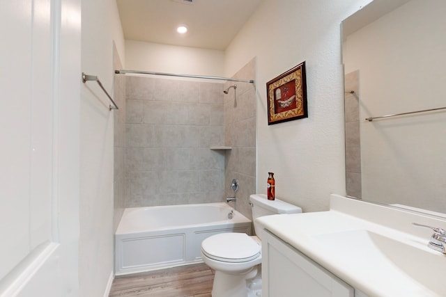 full bathroom with vanity, wood-type flooring, toilet, and tiled shower / bath