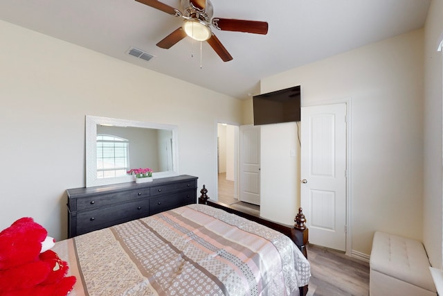 bedroom with vaulted ceiling, light hardwood / wood-style floors, and ceiling fan