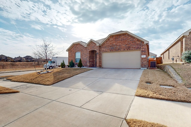 view of front of home featuring a garage and central air condition unit