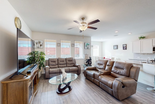 living room featuring ceiling fan and light hardwood / wood-style flooring