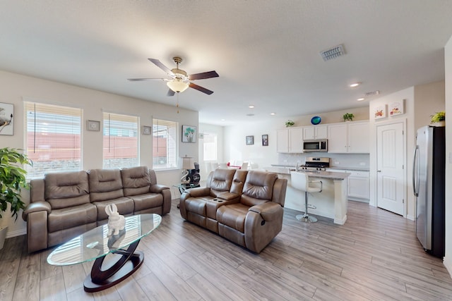 living room featuring ceiling fan and light wood-type flooring