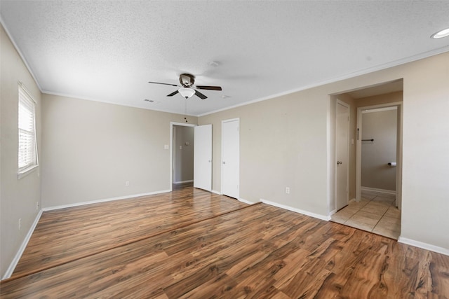 unfurnished bedroom with hardwood / wood-style flooring, ornamental molding, a textured ceiling, and ceiling fan