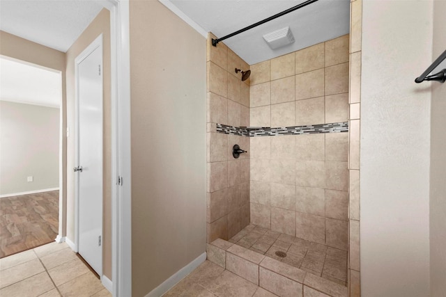 bathroom featuring tile patterned flooring and tiled shower