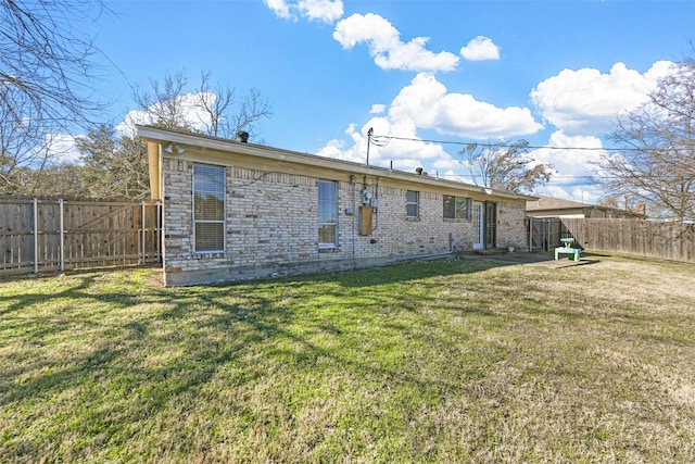 rear view of property featuring a lawn