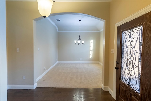 foyer featuring crown molding, dark hardwood / wood-style floors, and a chandelier