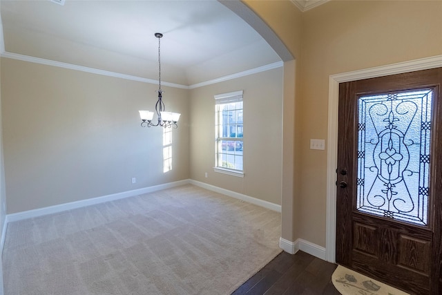 entryway with crown molding, wood-type flooring, and an inviting chandelier