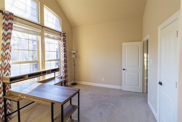 office space with vaulted ceiling and light carpet