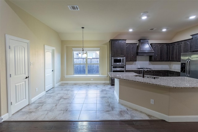 kitchen with premium range hood, dark brown cabinetry, sink, stainless steel appliances, and light stone countertops