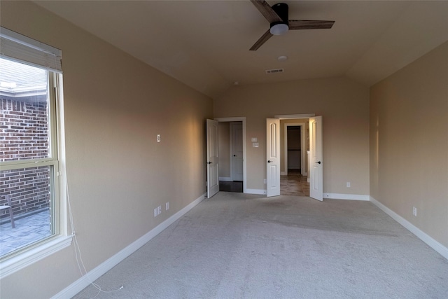 unfurnished bedroom featuring lofted ceiling, light colored carpet, and ceiling fan