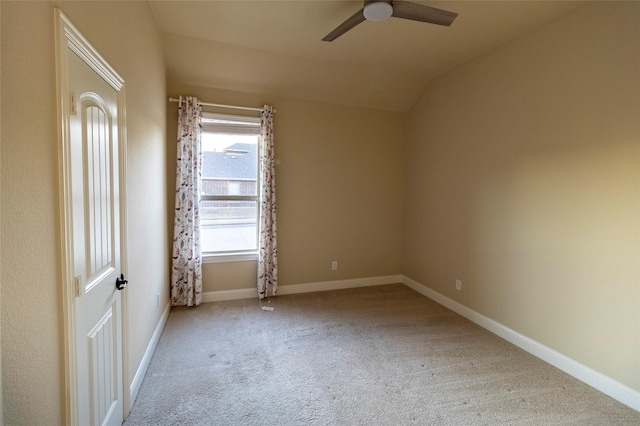 carpeted spare room featuring vaulted ceiling and ceiling fan