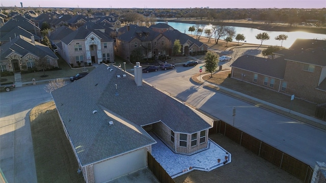 aerial view at dusk featuring a water view