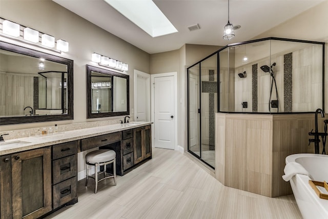 bathroom featuring separate shower and tub, vanity, and a skylight