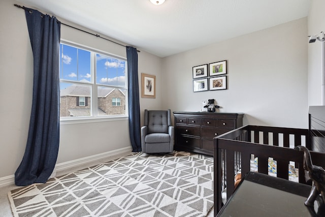 bedroom with light carpet and a nursery area