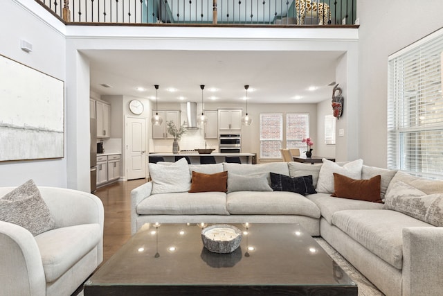 living room featuring wood-type flooring and a towering ceiling