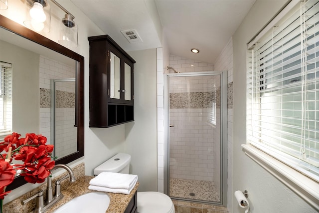 bathroom featuring lofted ceiling, a shower with shower door, and toilet