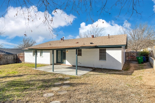 rear view of property with a patio and a lawn