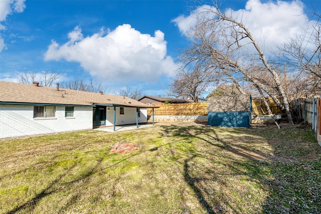 view of yard with a shed and a patio area