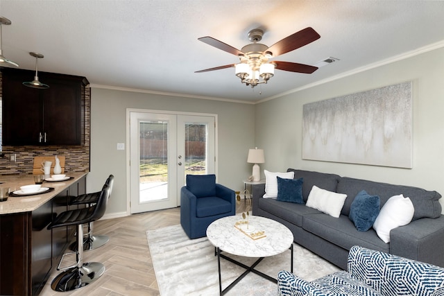 living room featuring light parquet floors, crown molding, ceiling fan, and french doors