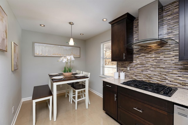 kitchen with dark brown cabinetry, wall chimney exhaust hood, tasteful backsplash, pendant lighting, and black gas stovetop