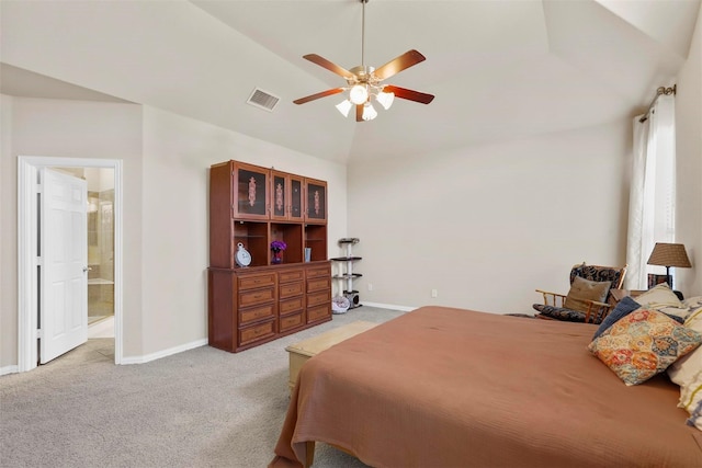 bedroom with light carpet, vaulted ceiling, ceiling fan, and ensuite bathroom