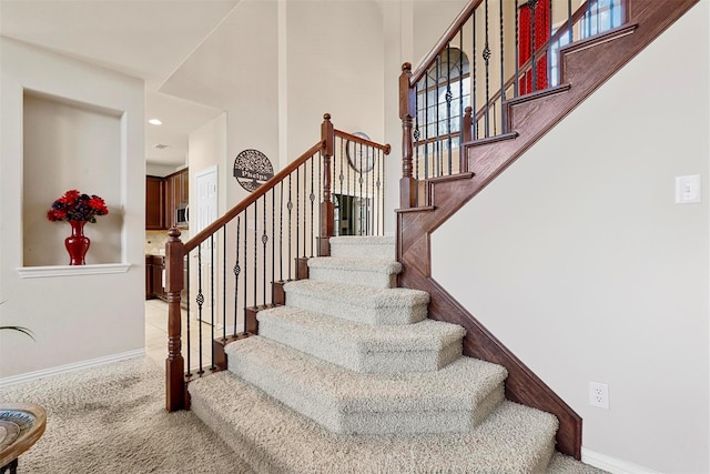 stairway featuring a healthy amount of sunlight and carpet