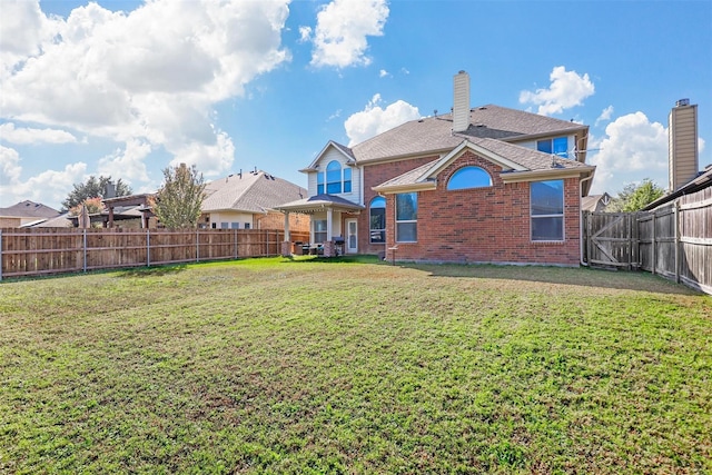 rear view of house with a yard