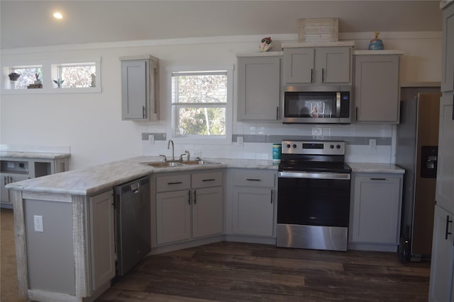 kitchen with appliances with stainless steel finishes, sink, and gray cabinetry